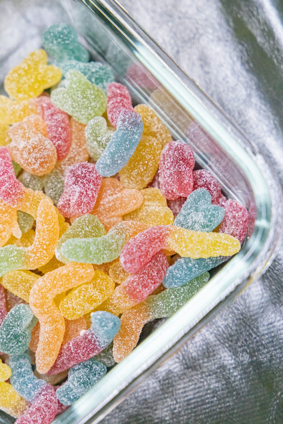 Assorted sugar-coated gummy candies arranged in a glass dish.