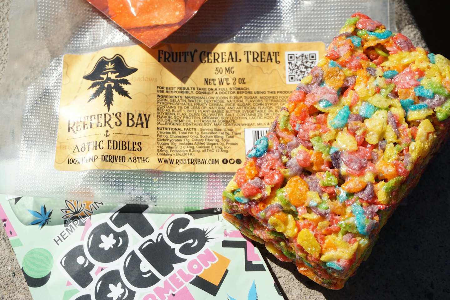 Fruity cereal treat and watermelon candy packages on a grey surface.